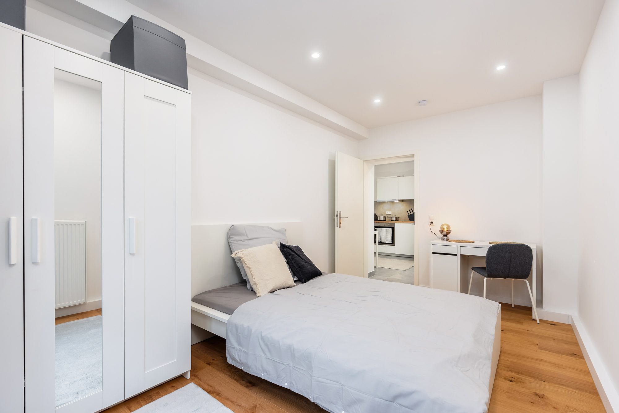Möbliertes Zimmer mit Kleiderschrank, Bett und Schreibtisch